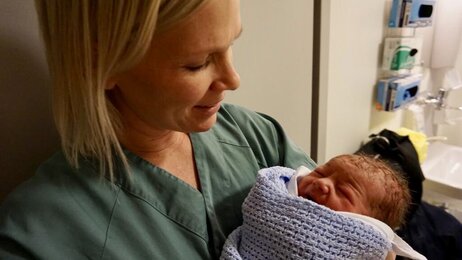 Helene Normann Furnes, jordmor Bildet viser jordmoren Helene Normann Furnes med et nyfødt barn i armene.