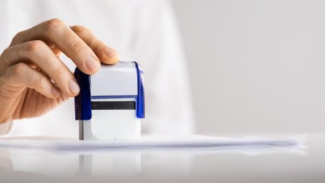 Spesialgodkjenning Bildet viser en mann som er i ferd med å stemple et papir
