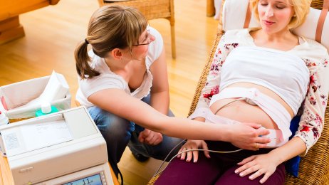 Bildet viser en gravid kvinne som blir undersøkt av jordmor