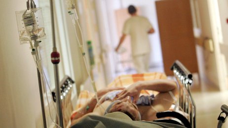 Sykehus Korridorbilde fra sykehus hvor det ligger en pasient. Helsepersonell går bortover