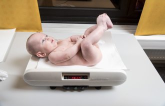 Baby veies Bildet viser en baby som blir veid på helsestasjonen.