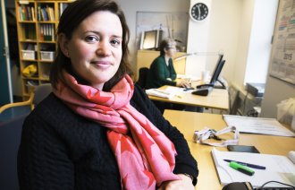 Leder for nattjenestensykepleier Elena Sandgathe, som er sykepleier, på kontoret sitt. I bakgrunnen sitter Åshild Bjånesøy, assisterende gruppeleder. 