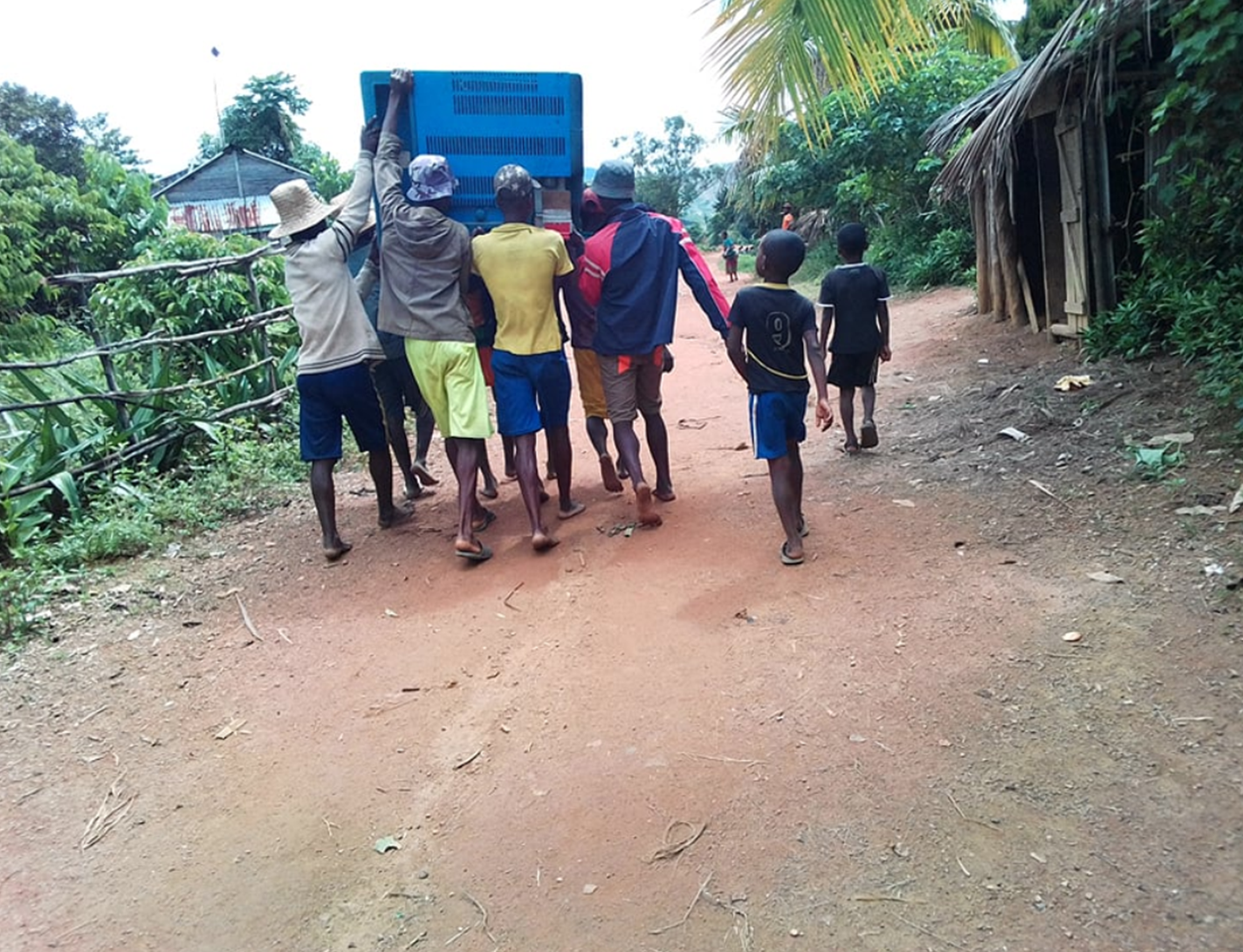 Transport av vaksiner på Madagaskar Bildet viser transport av vaksinar på Madagaskar, der kjølebagen med vaksinar transporteres av sju personer som bærer sammen