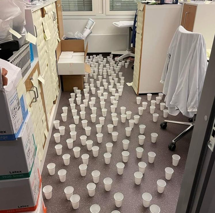 mr.vid19 Bildet viser et kontor med mange hvite plastkopper, fylt med vann.