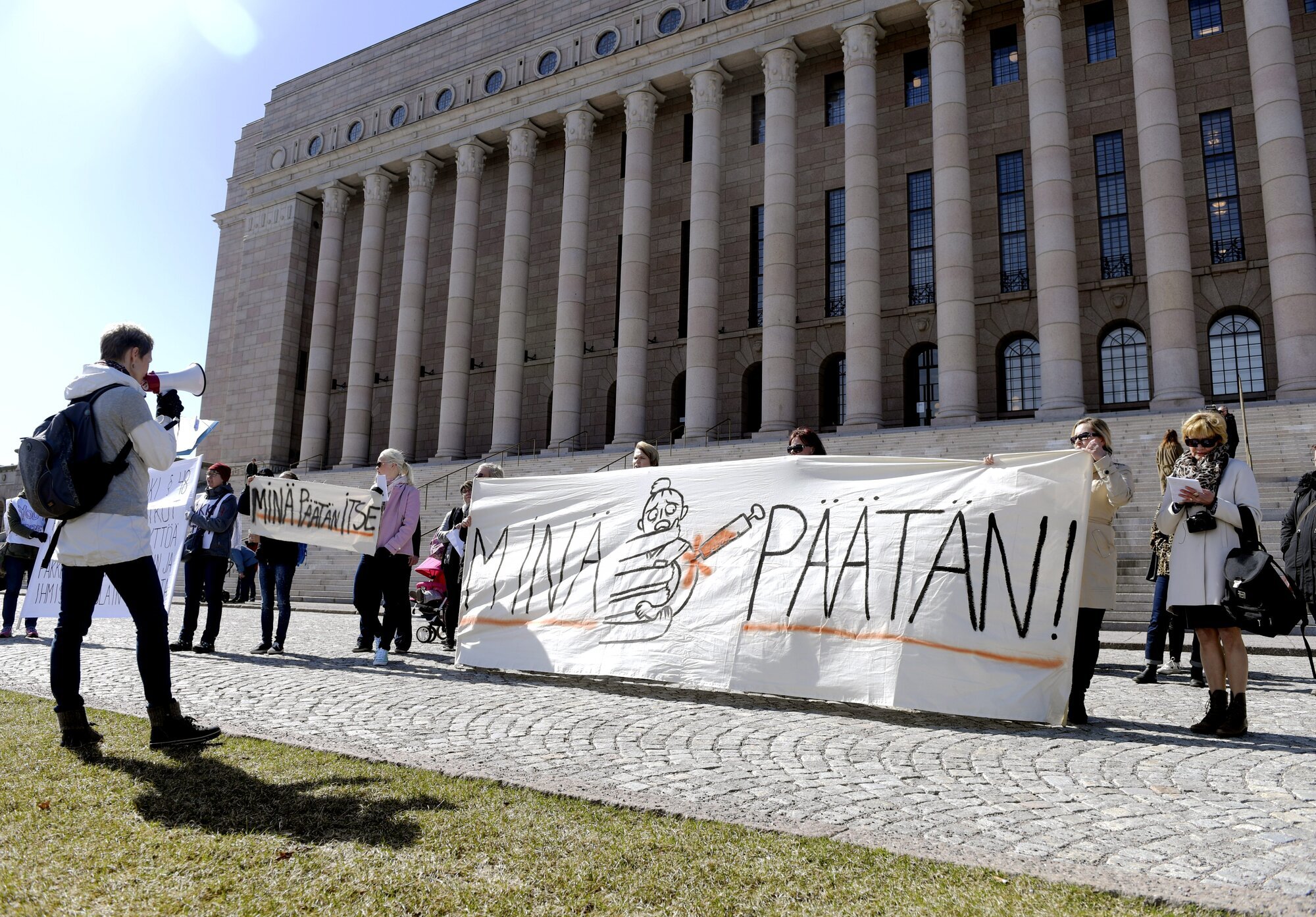 Finland, lov mot smittsomme sykdommer Bildet viser demonstranter utenfor Finlands parlament.