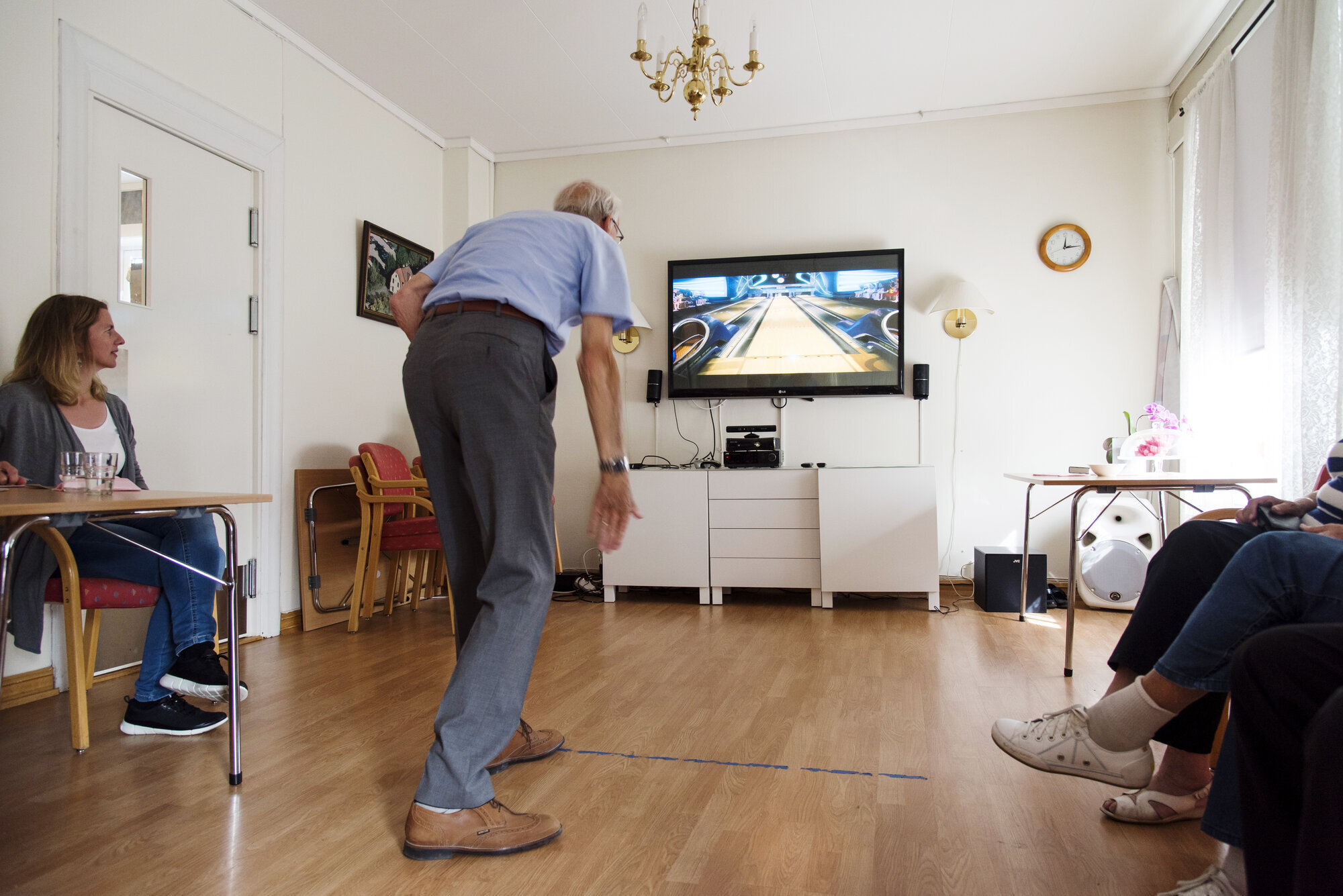 Stadig flere får øynene opp for dataspillingens helsefremmende potensiale. Bildet viser en eldre mann som spiller bowling på storskjerm ved hjelp av Kinect.