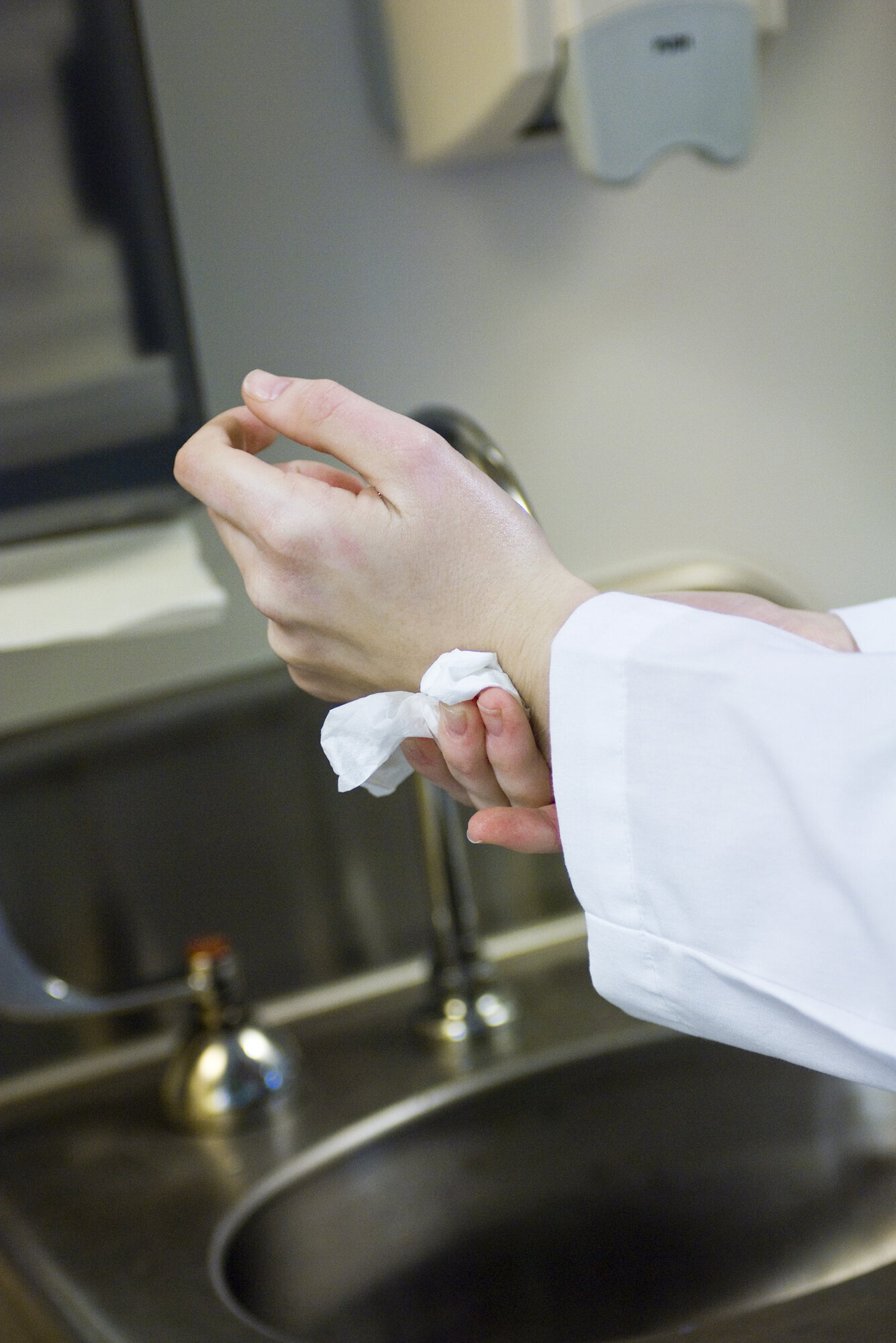 Viser hender som tørker seg med et papirhåndkle. Slurver med håndhygiene ved Universitetssykehuset i Nord Norge.