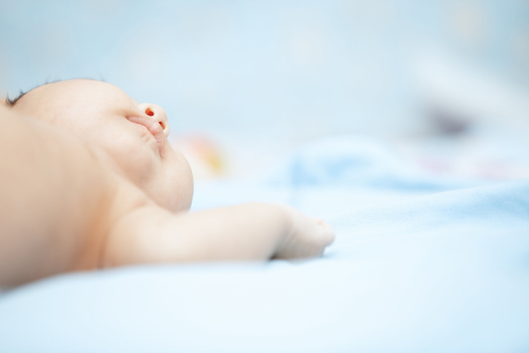 Baby Bildet viser en guttebaby på lyseblått teppe.