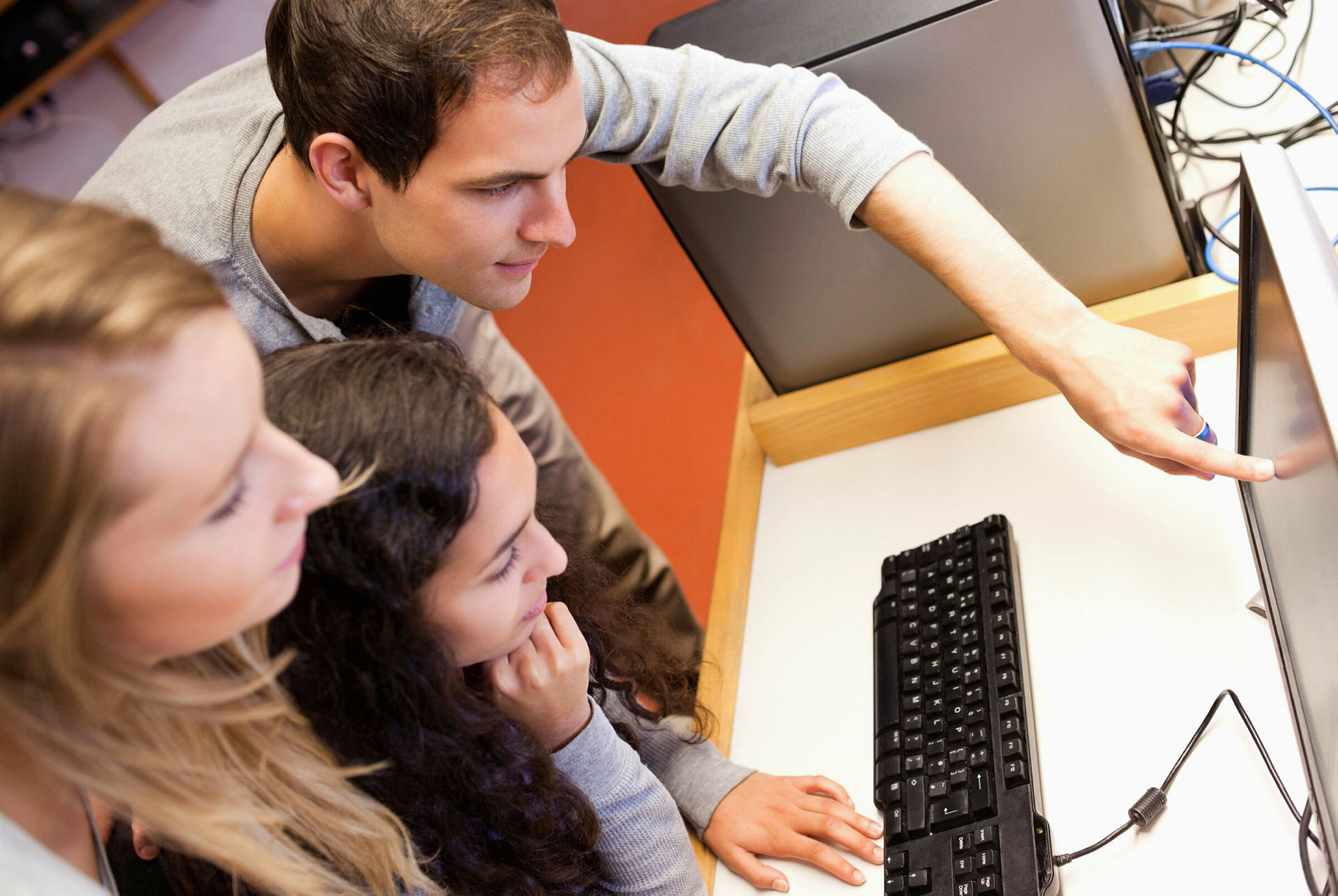 Studenter Tre unge mennesker ser på en pc.