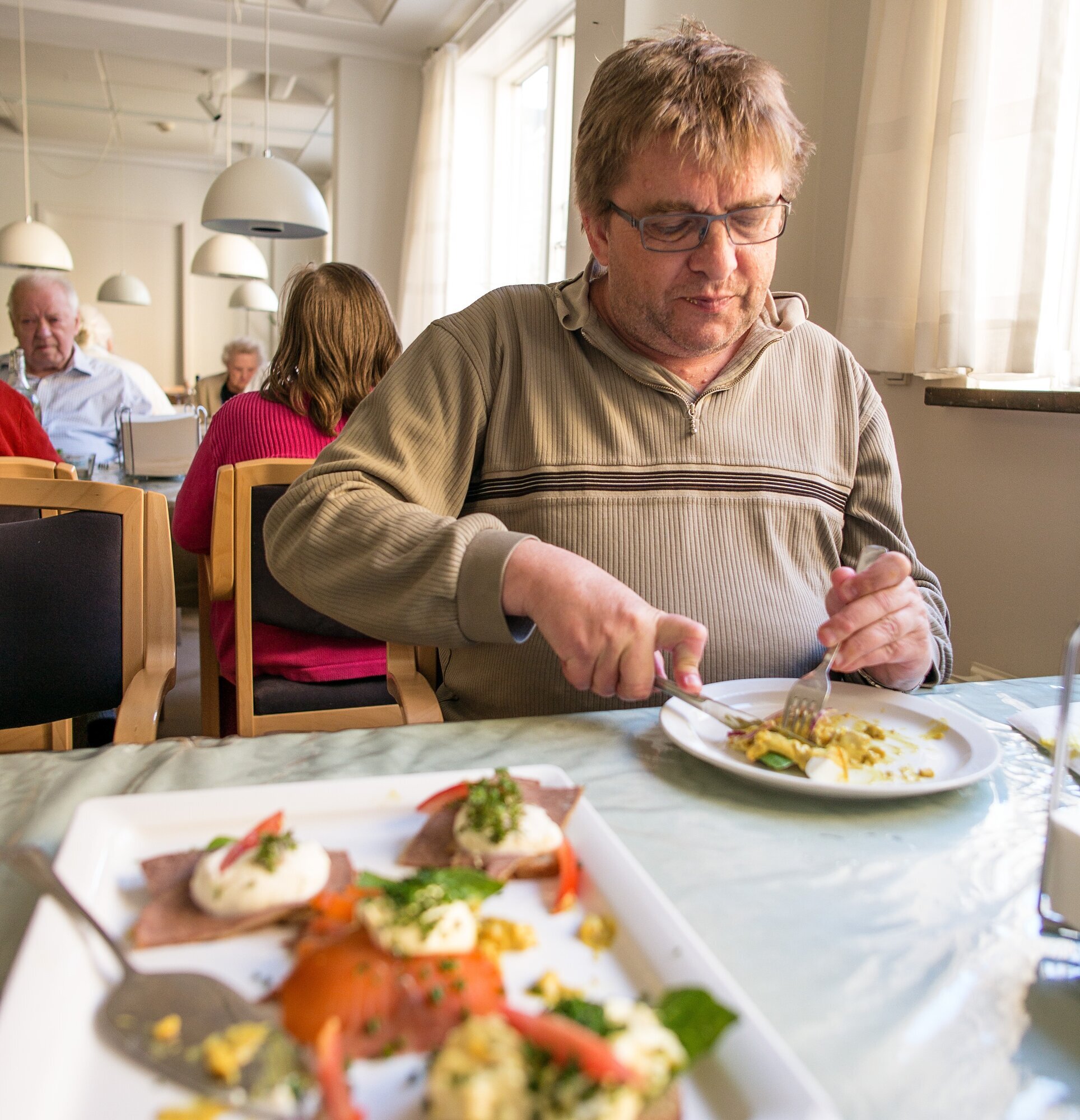 Niels Hansen, Rundskuedagens plejecenter, København Bildet viser Niels Hansen som sitter og spiser.