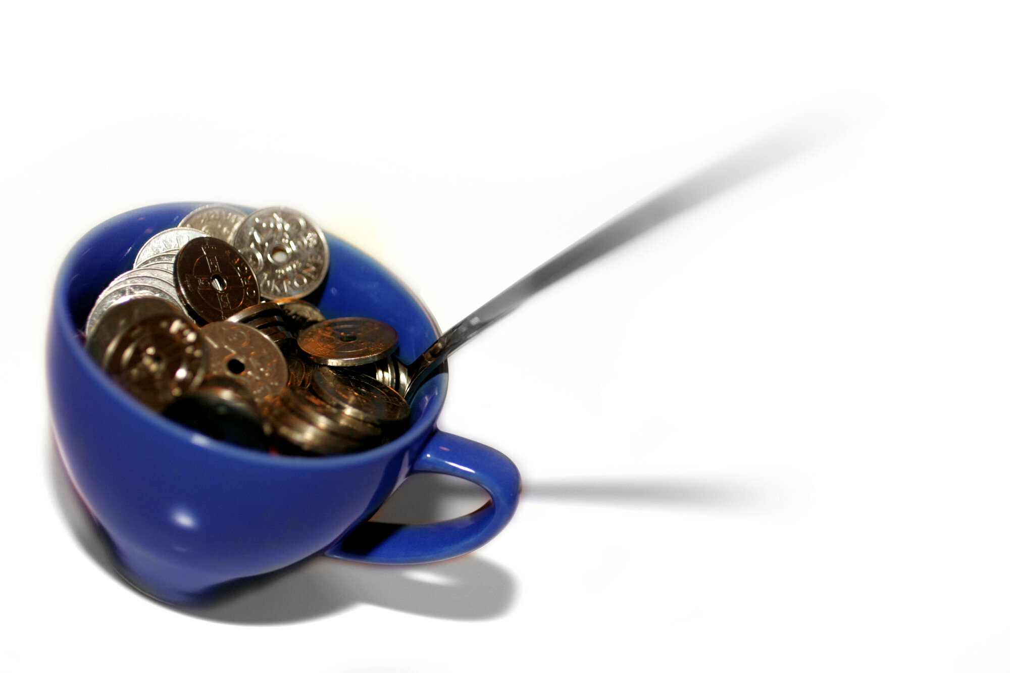 En blå kopp med kronestykker En blå kopp med kronestykker