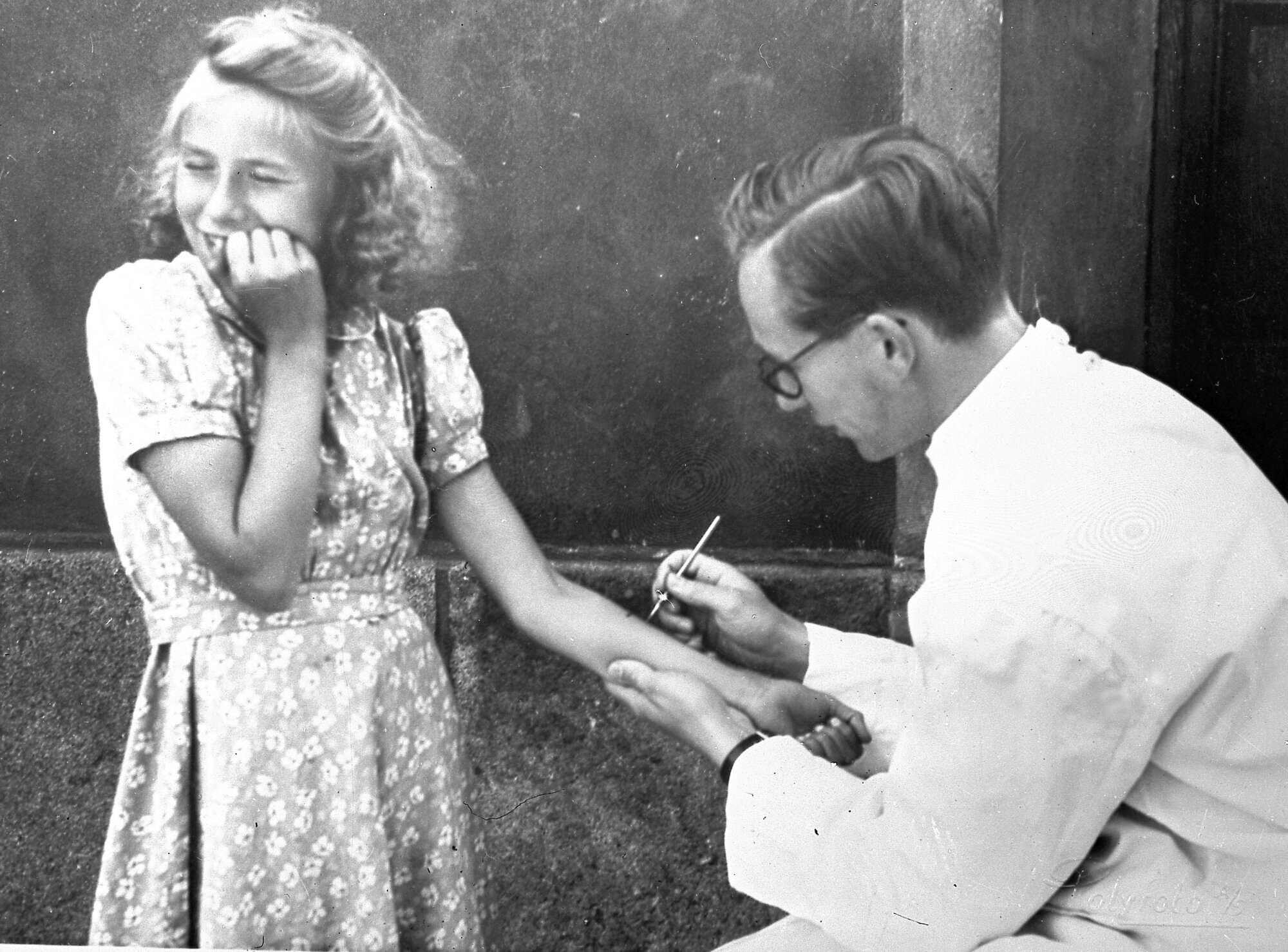 Tuberkulintest, tuberkulose Bildet viser en jente som ser bort, med et lite angsfylt smil rundt munnen, mens en lege tar tuberkulintest.