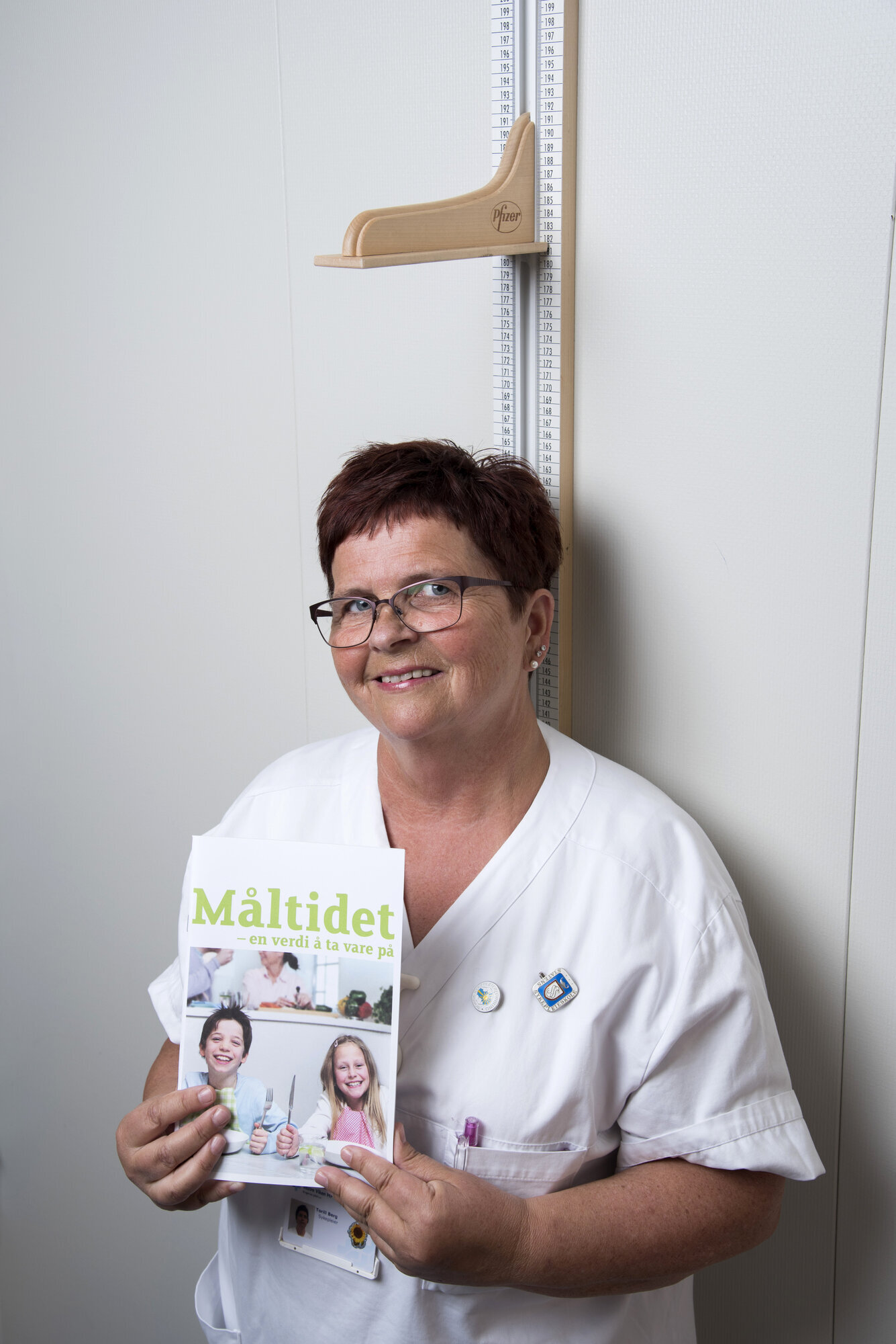Torill Berg Torill Berg poserer med bladet "Måltidet", under høydemålingsstativ ved overvektsklinikken.