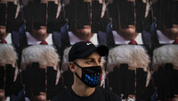 USA, valg, sykepleier Bildet viser en mann med maske som det står Biden på, foran nedtusjete plakater av Trump.