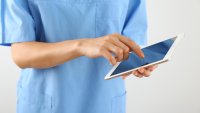 Bildet viser en sykepleier som skriver på en Ipad
