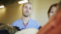 Sykepleier tar imot pasient på akuttmottaket Bildet viser en sykepleier som ser med et godt blikk på en pasient vi bare skimter litt av kroppen til.