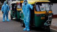 India, New Delhi Bildet viser to rickshaw-ambulanser med to sjåfører ikledd smittevernutstyr.