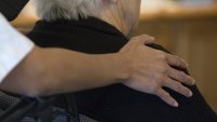 Eldre kvinne og sykepleier En sykepleier holder rundt en eldre kvinne