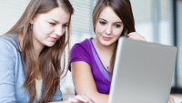 To studenter Bildet viser to kvinnelige studenter som ser inn i en pc-skjerm.