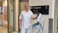 Bildet viser Anne Beathe Bohne som triller et apparat i en sykehuskorridorus Bildet viser Anne Beathe Bohne som triller et apparat i en sykehuskorridorus