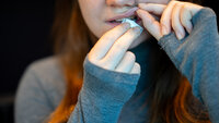 Bildet viser en ung kvinne som legger inn en pris snus.