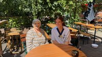 Paulus Sykepleier og beboer sitter i St. Pauli Biergarten