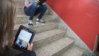 Instagram Elever sitter i en trapp og sjekker Instagram på iPad.