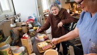 Hjemmesykepleier tilbereder måltid. Bildet viser en hjemmesykepleier som tilbereder et måltid til brukeren.
