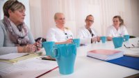 Tverrfaglig team av helsepersonell Bildet viser fagfolk fra ulike helseprofesjoner som sitter rundt et bord