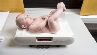Bildet viser en baby som blir veid på helsestasjonen.