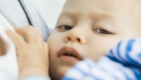 Liten gutt Illustrasjonsfoto av et lite barn som bæres inntil en voksen