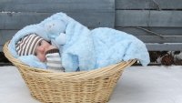 Bilde av en liten baby som ligger i en kurv med blått teppe. Bilde av en liten baby som ligger i en kurv med blått teppe.
