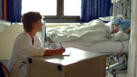 Sykepleier skriver dagbok Bildet viser en sykepleier som skriver dagbok for en pasient