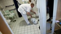 Ufaglært Helge Kristiansen på Vinderen Bo og Servicesenter rydder på badet.