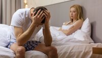 Impotens Illustrasjonsfoto av mann og kvinne som sitter i sengen. Mannen er tydelig frustrert.