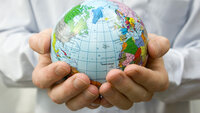 En mann holder en liten globus i hendene En mann holder en liten globus i hendene