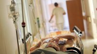 Sykehus Korridorbilde fra sykehus hvor det ligger en pasient. Helsepersonell går bortover