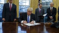 Donald Trump Bildet viser Donald Trump som signerer papirer.