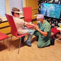 Bildet viser en gutt som har på VR-briller mens en anestesisykepleier legger inn perifert venekateter